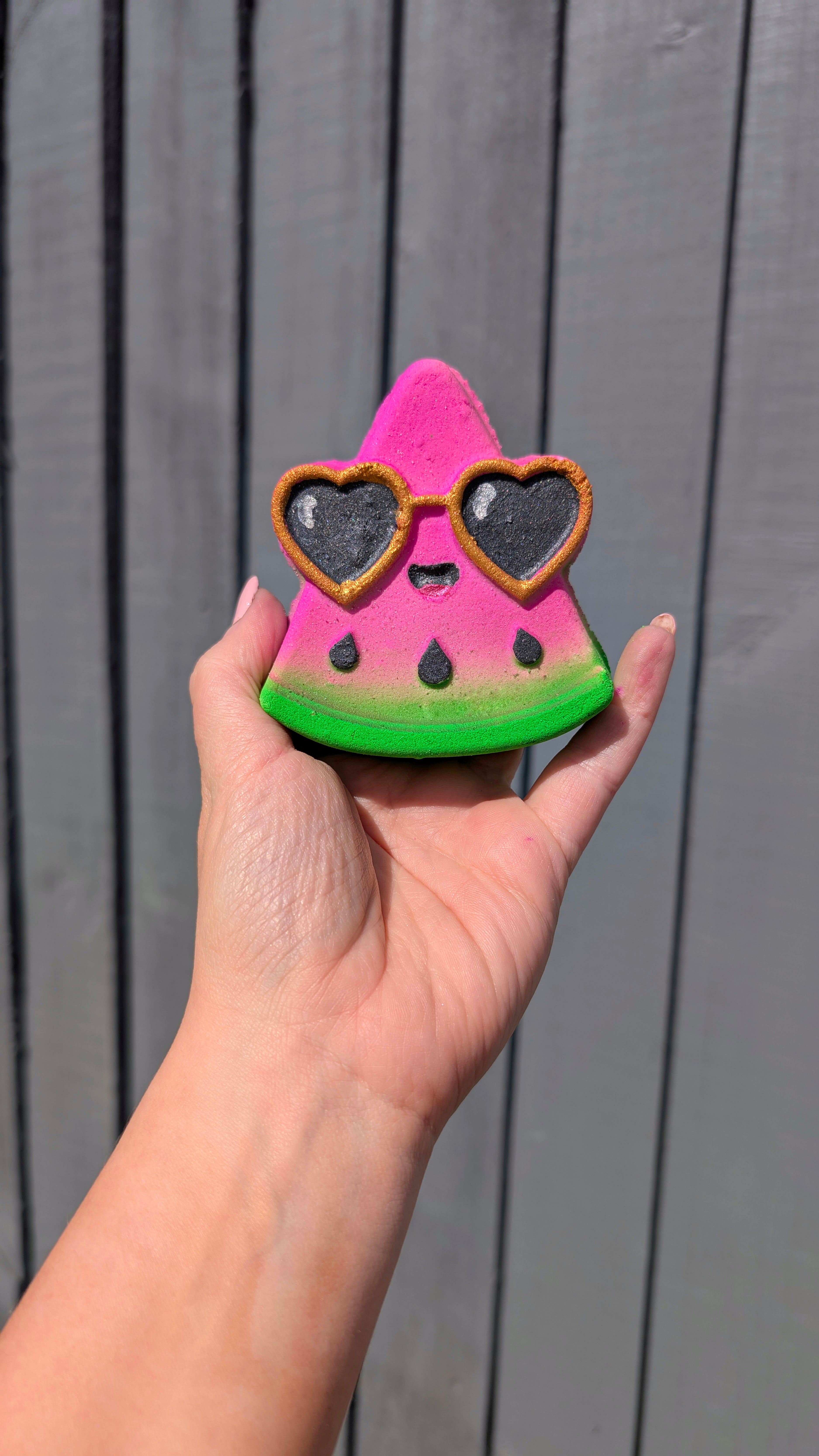 Hand holding a Watermelon slice shaped bath bomb from Fizz Bomb Cosmetics, featuring black and gold detailing – a fun, summer themed bath treat perfect for gifting or relaxing self care days.
